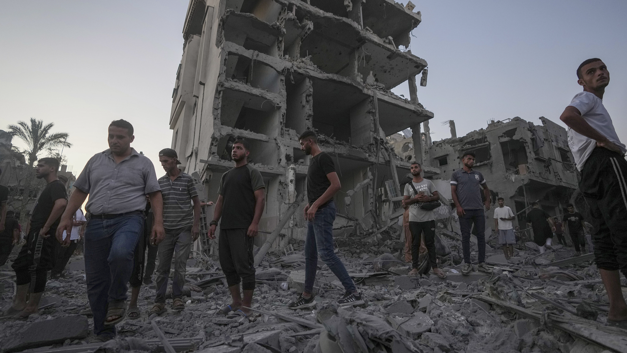 Palestinians walk through rubble after an Israeli airstrike in Deir al Balah, the Gaza Strip, August 6, 2024. /CFP