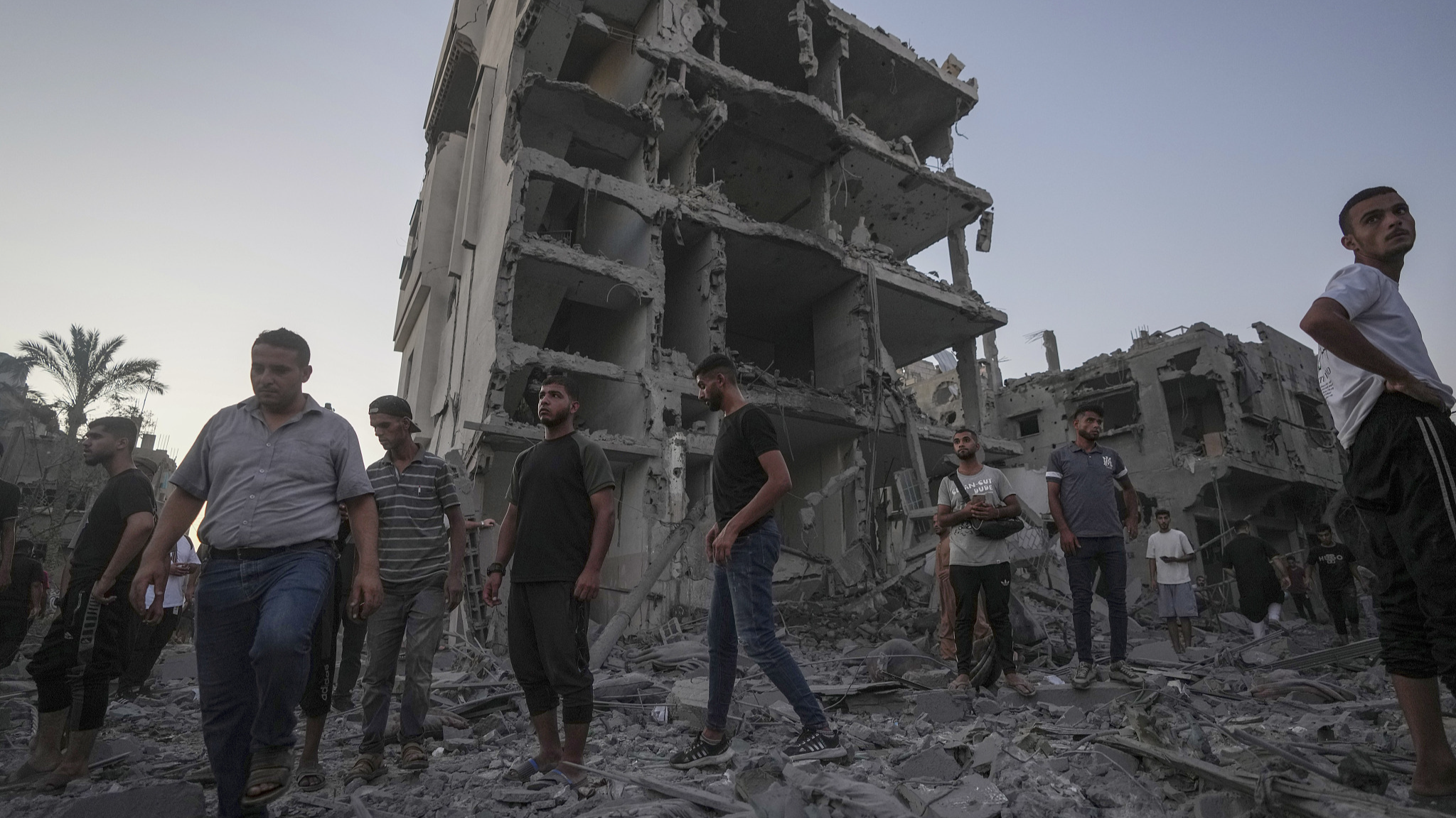 Palestinians walk through rubble after an Israeli airstrike in Deir al Balah, the Gaza Strip, August 6, 2024. /CFP