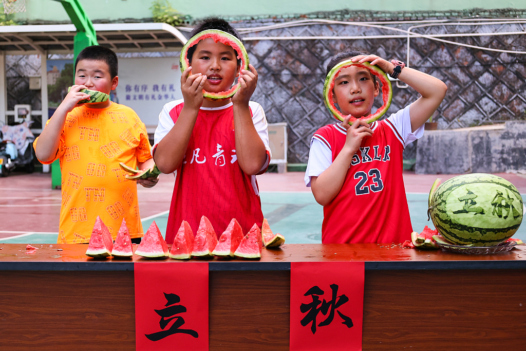 Anak-anak makan semangka bersama untuk merayakan dimulainya musim gugur di Jinhua, Provinsi Zhejiang, pada 6 Agustus 2024. /CFP