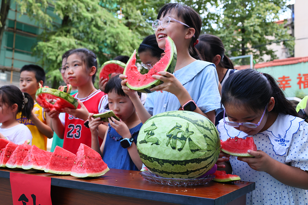 Anak-anak makan semangka bersama untuk merayakan dimulainya musim gugur di Jinhua, Provinsi Zhejiang, pada 6 Agustus 2024. /CFP