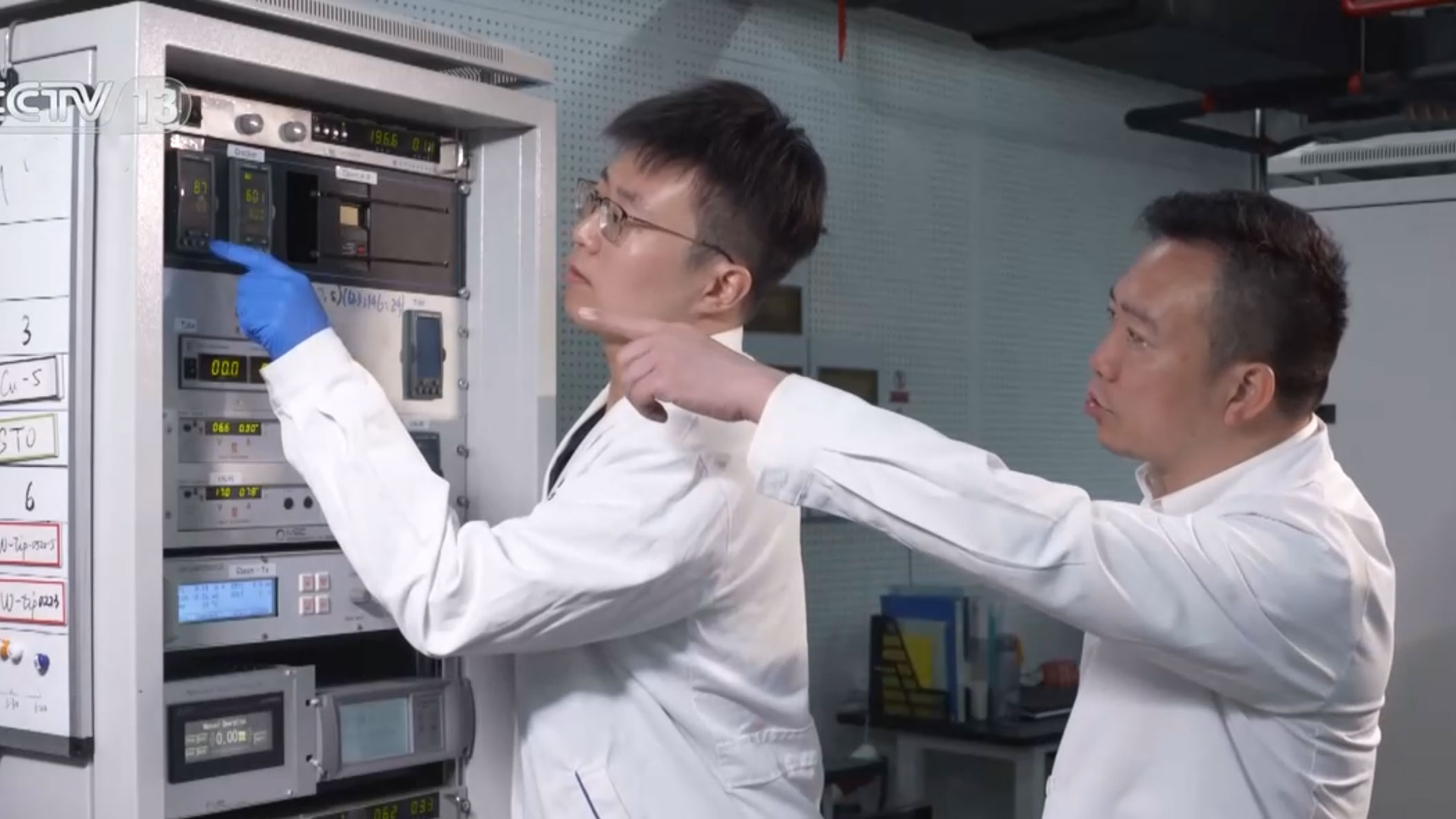 Tian Zi'ao (L) and Di Zengfeng (R), both researchers at the Shanghai Institute of Microsystem and Information Technology, Chinese Academy of Sciences, check up on scientific devices. /China Media Group