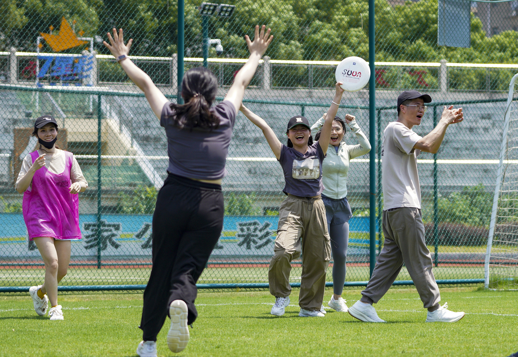People playing frisbee on a green field, Nanchang, the capital city of east China's Jiangxi Province, May 25, 2024. /CFP