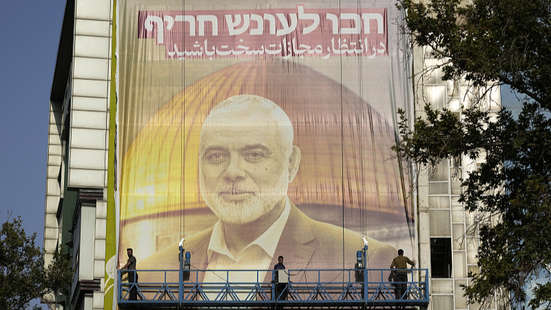 Iranian workers install a huge banner on a wall showing a portrait of slain Hamas leader Ismail Haniyeh in Tehran, Iran, July 31, 2024. /CFP