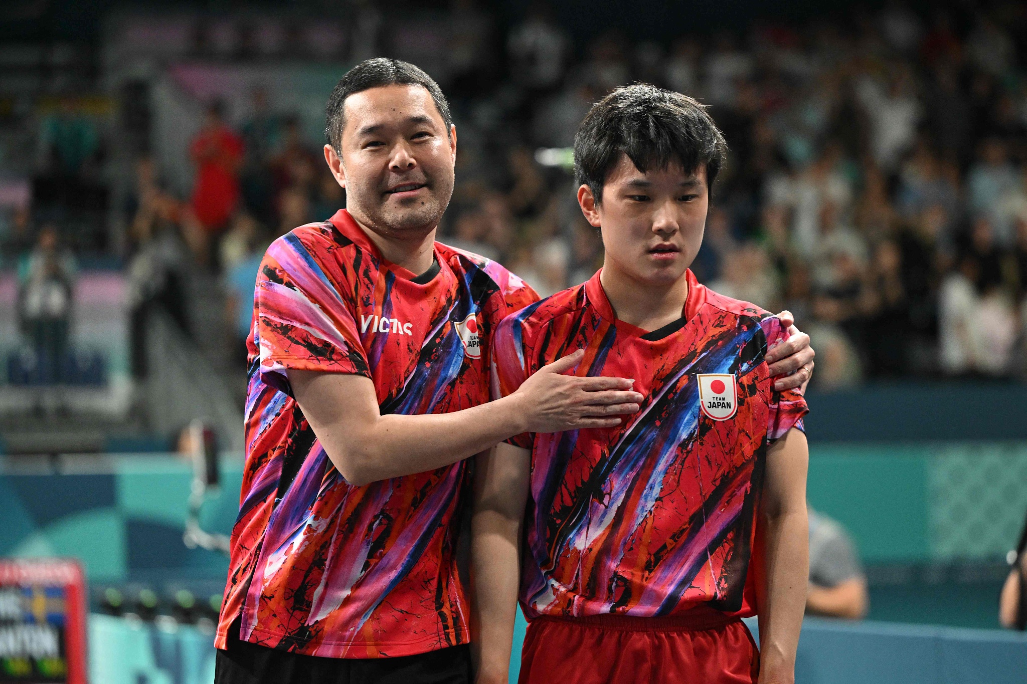 Coach Kunihito Tasei (L) of Japan consoles his player Tomokazu Harimoto following their side's loss to Sweden in the men's team table tennis semifinals at the 2024 Summer Olympics in Paris, France, August 7, 2024. /CFP