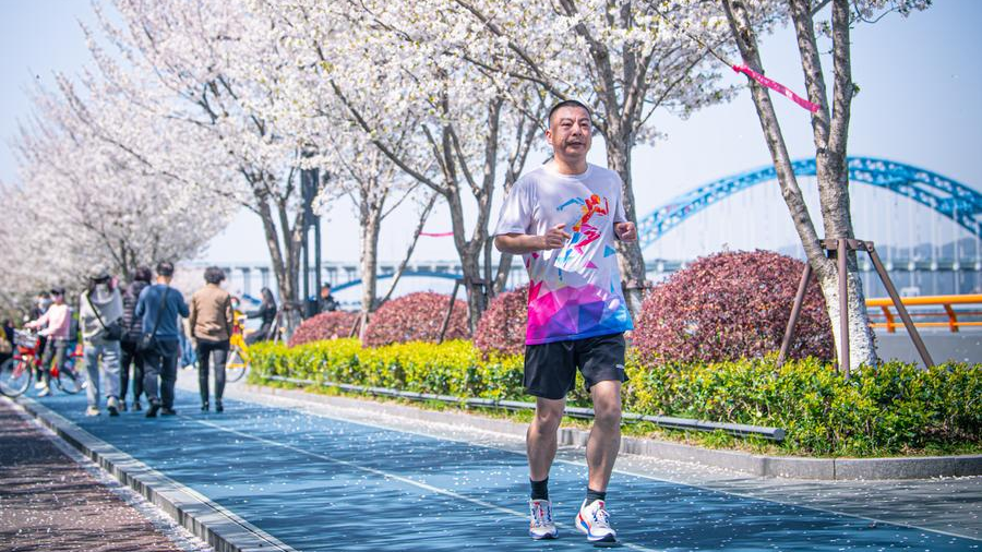 A citizen runs on a greenway for exercise in Binjiang District in Hangzhou, east China's Zhejiang Province, March 29, 2024. /Xinhua