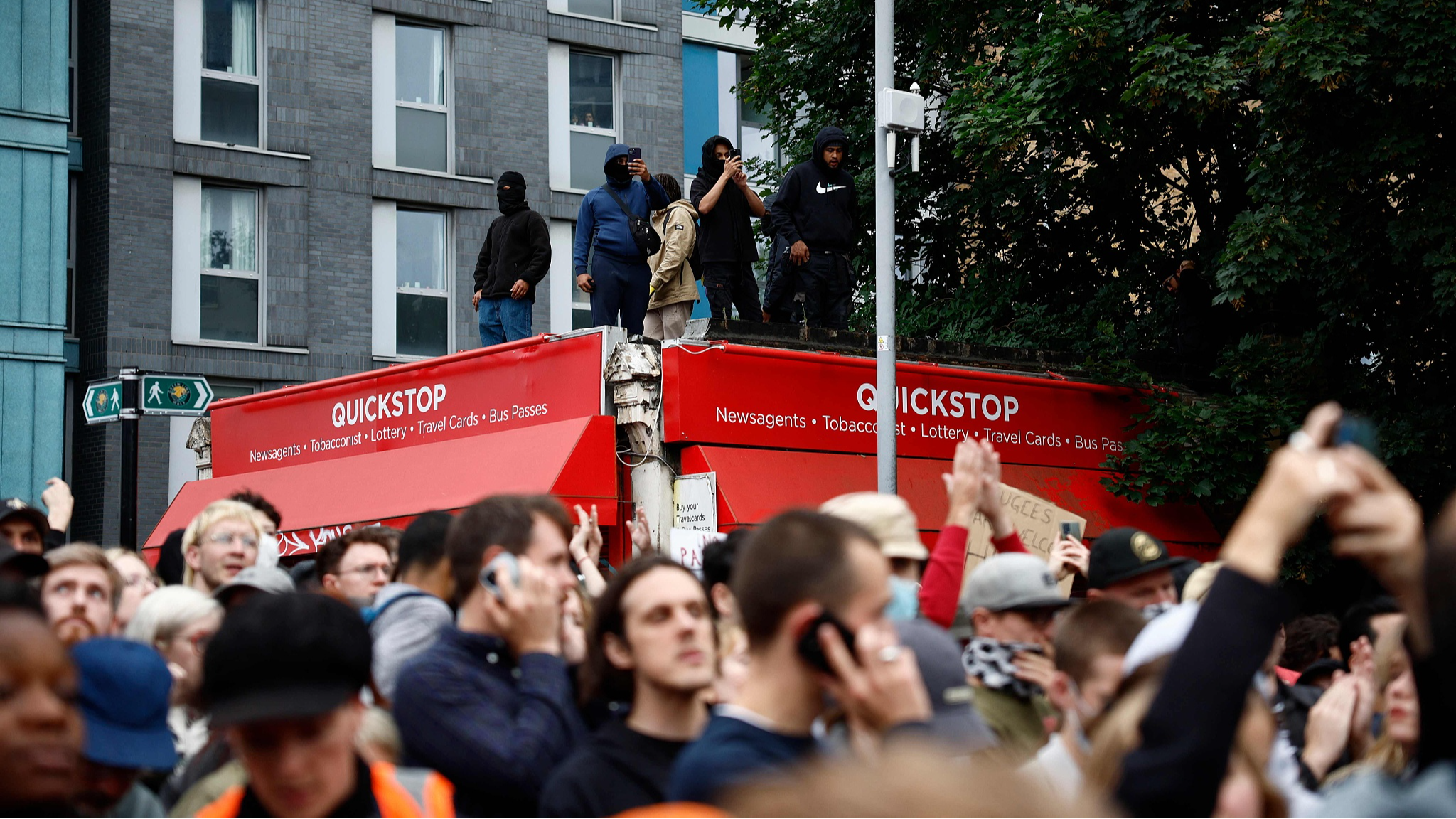 Protesters stand atop a convenience store during a counter-demonstration against an anti-immigration protest called by far-right activists in the Walthamstow suburb of London, August 7, 2024. /CFP