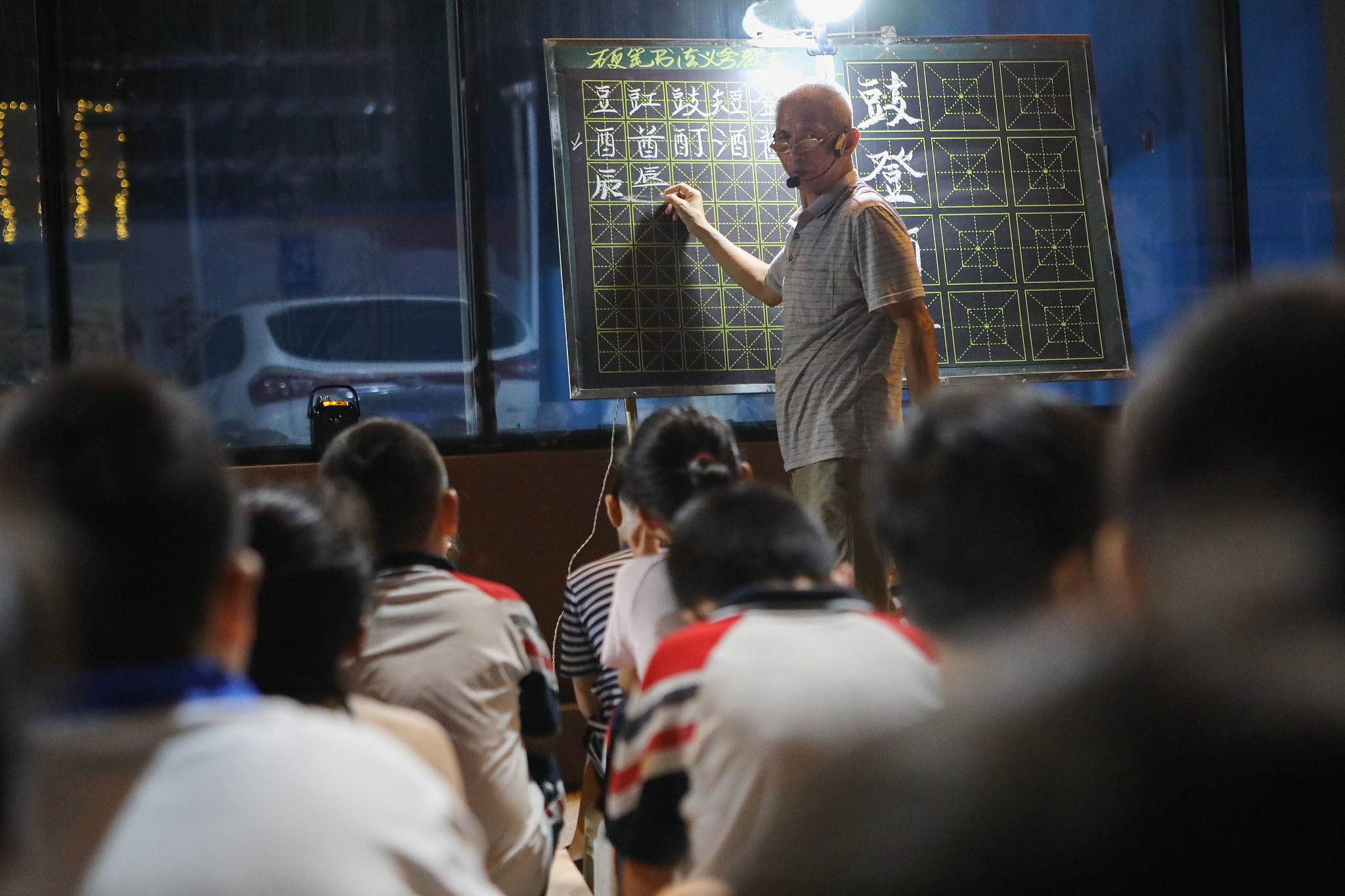 A senior offers free hard-pen calligraphy lessons to students on the streets of Handan City, north China's Hebei Province, September 6, 2023. /CFP