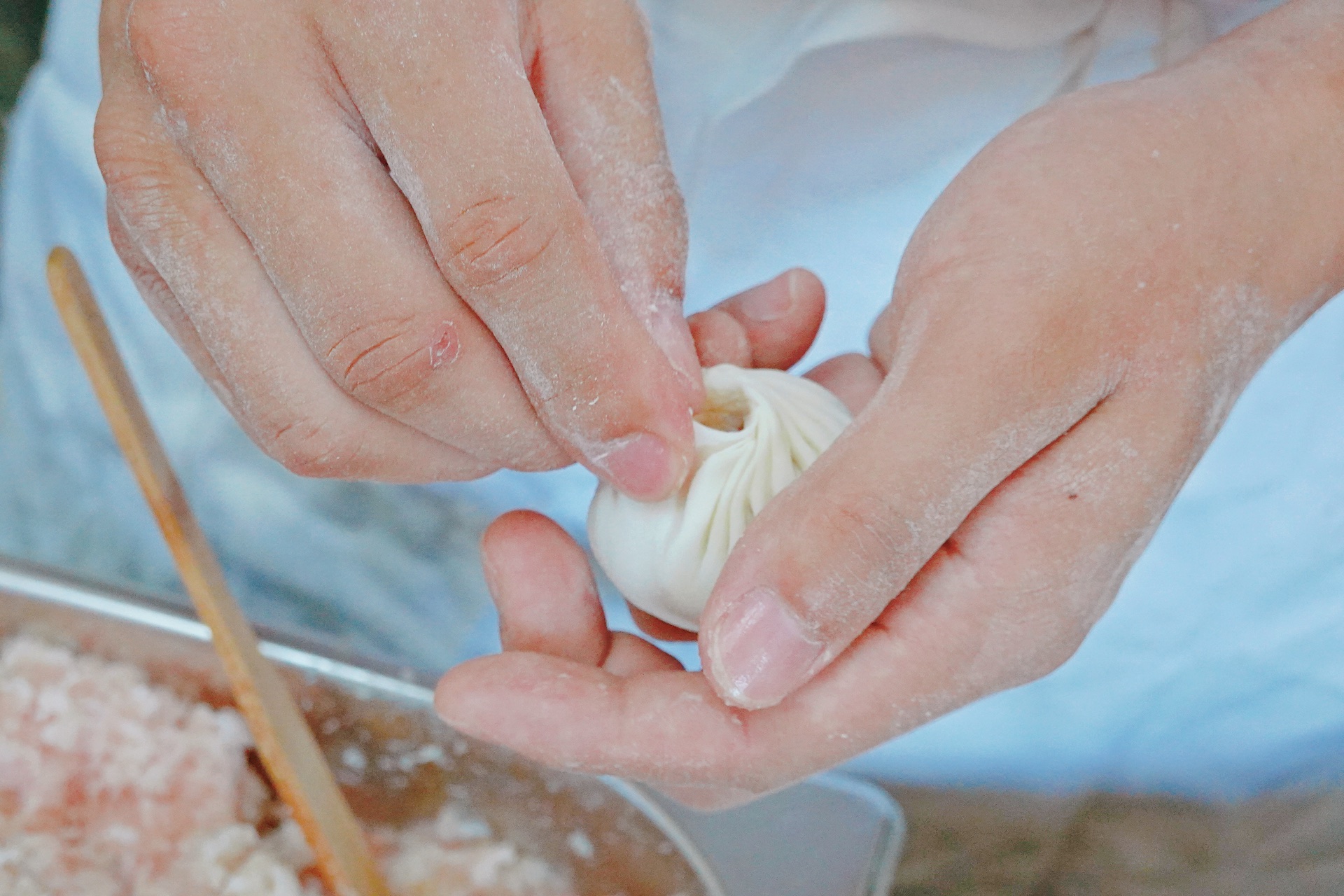 A chef seals the top of a Wuxi-style steamed bun. /CGTN