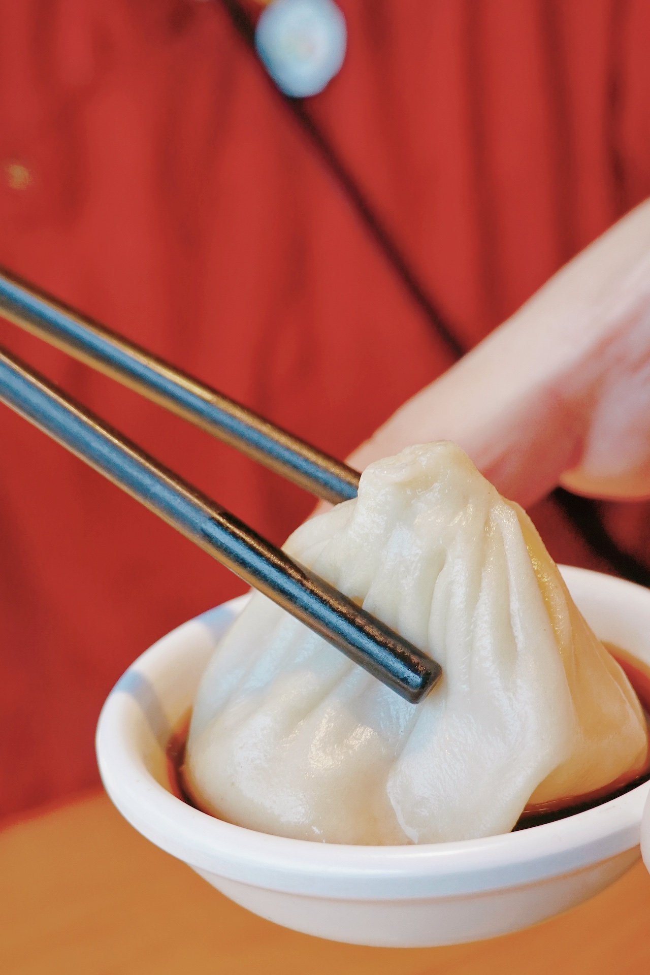 People can dip the xiaolongbao into vinegar first to cool it off a bit and then take a tiny bite on the side to make a little hole. /CGTN