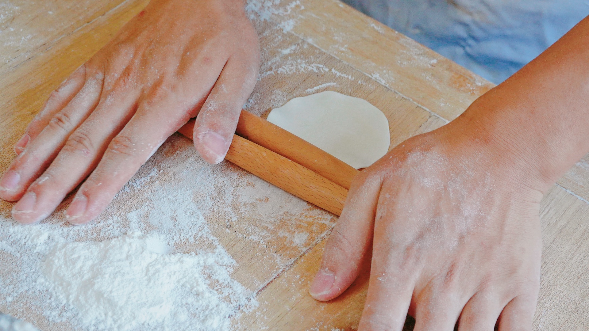 Two rolling pins are used to roll the dough into wrappers. /CGTN