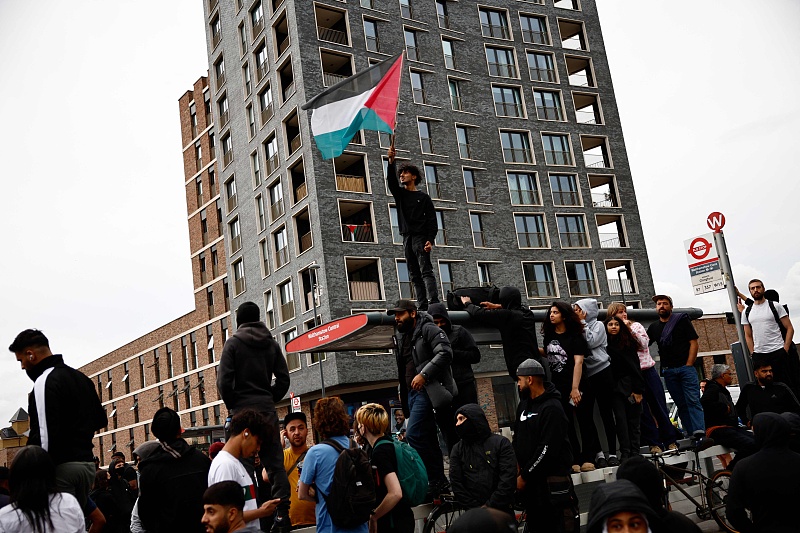 Seorang pengunjuk rasa mengibarkan bendera Palestina selama demonstrasi tandingan terhadap protes anti-imigrasi yang diserukan oleh aktivis sayap kanan di pinggiran kota Walthamstow, London, 7 Agustus 2024. /CFP