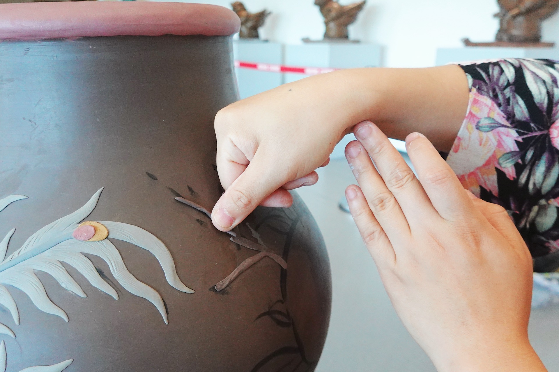 An artist demonstrates Jun-glazed pottery craftsmanship with her thumb and flexible finger work to emboss designs on a pottery surface at the Yixing Ceramic Museum in Wuxi, Jiangsu Province. /CGTN