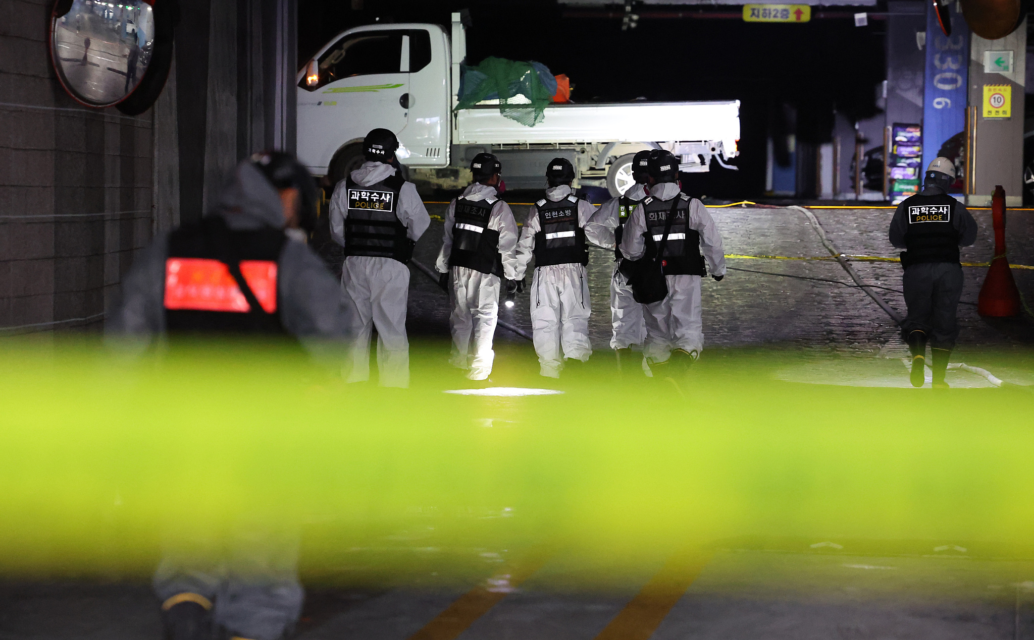Officials from the police, fire department and National Forensic Service conduct a second joint forensic examination of an electric car that caught fire in the underground parking lot of an apartment complex in Incheon, August 2, 2024. /CFP