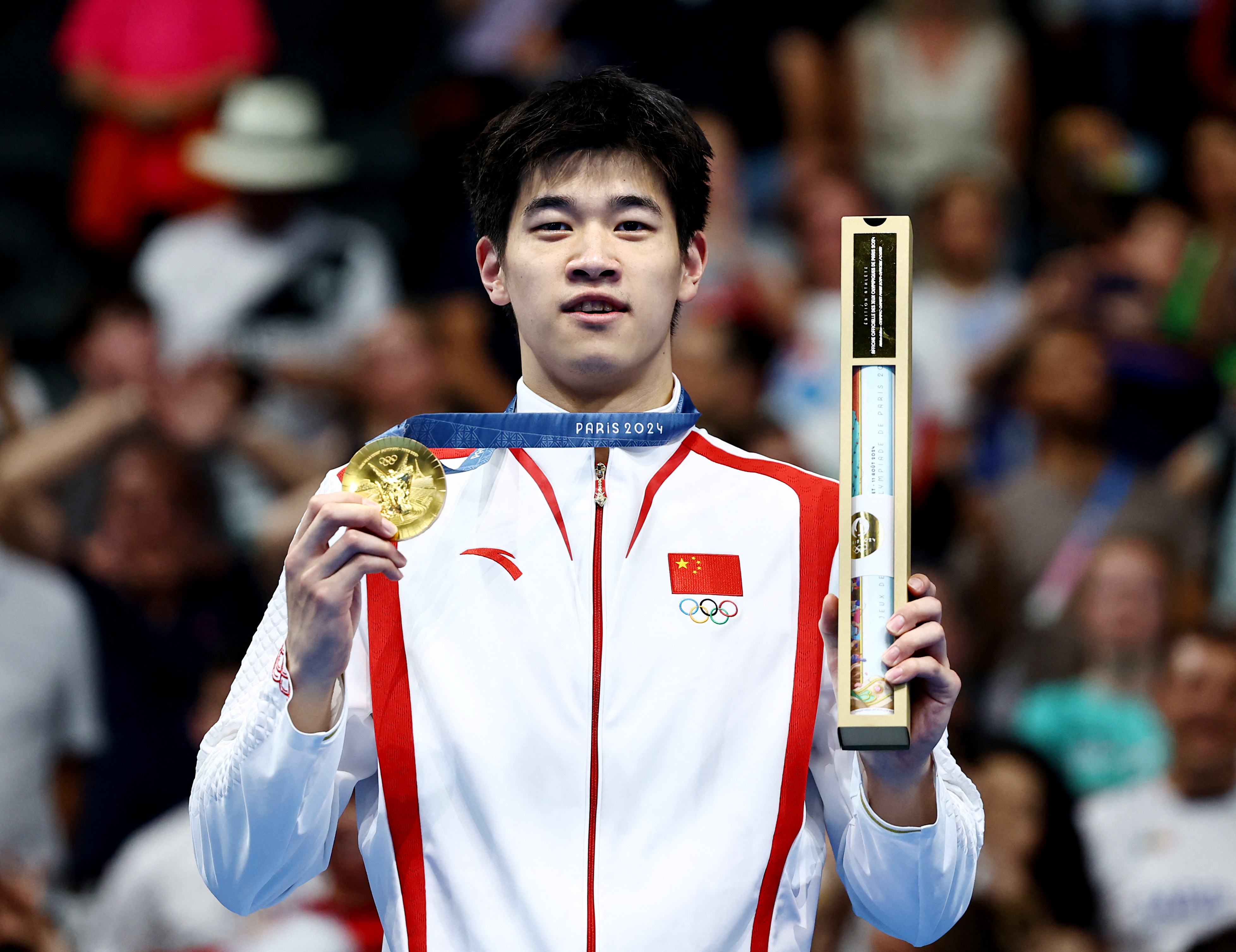 Chinese swimmer Pan Zhanle shows his gold medal for the men's 100m freestyle at the Paris 2024 Olympic Games in Paris, France, July 31, 2024. /IC