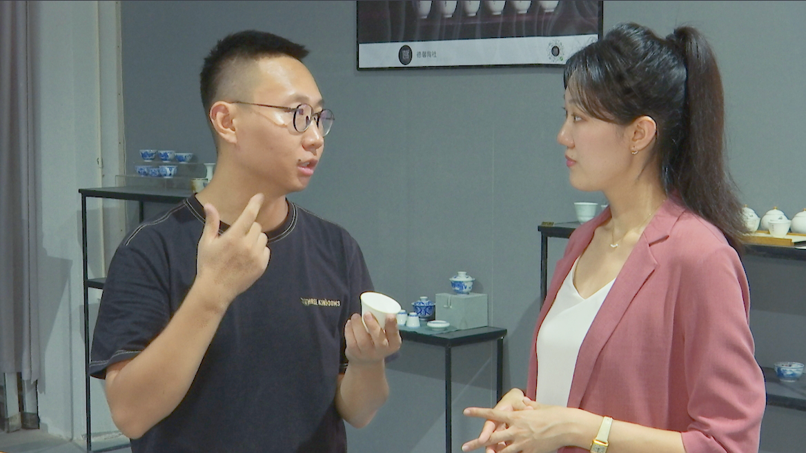 Sun Qiang (L), a ceramist from the city of Taiyuan in north China's Shanxi Province, shows CGTN reporter Guo Meiping his works. /CGTN