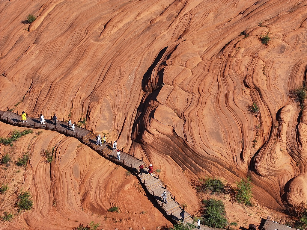 A photo taken on August 13, 2024 shows visitors flocking to Wave Valley to marvel at the breathtaking views of the Danxia landforms in Yulin, Shaanxi Province. /CFP