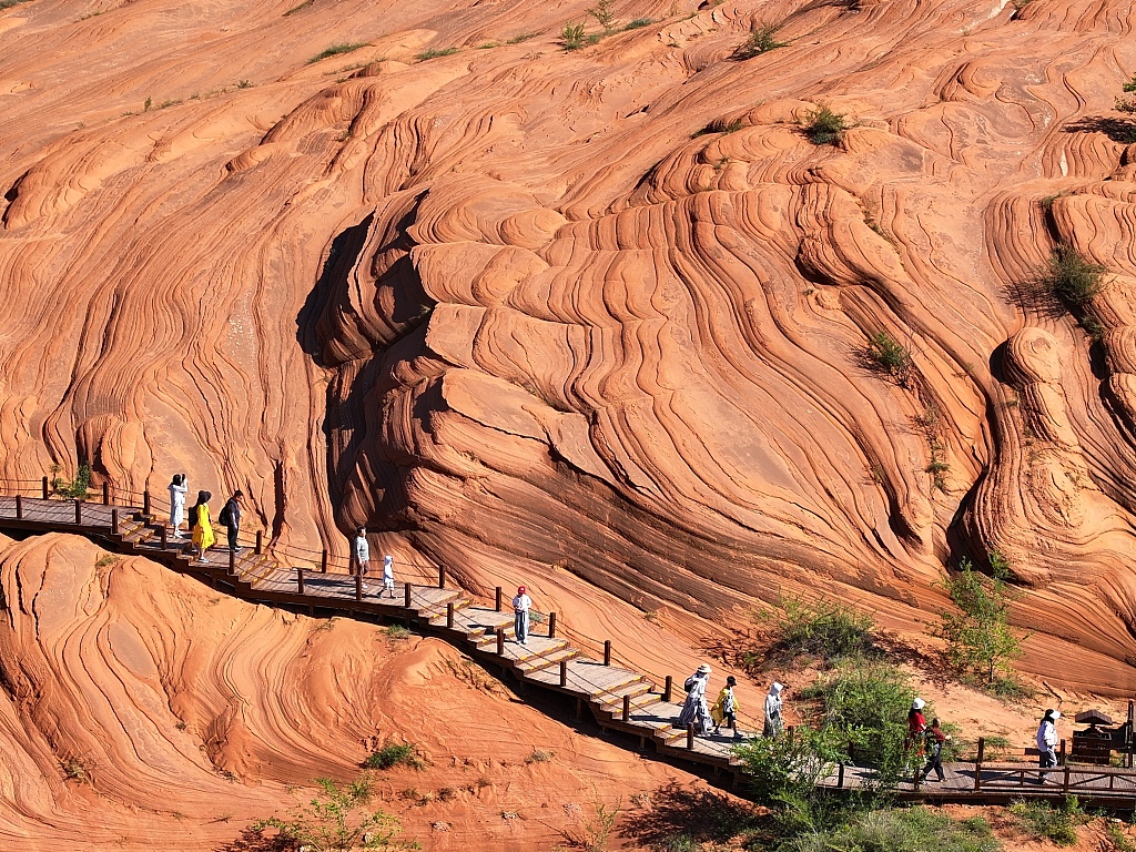 A photo taken on August 13, 2024 shows visitors flocking to Wave Valley to marvel at the breathtaking views of the Danxia landforms in Yulin, Shaanxi Province. /CFP