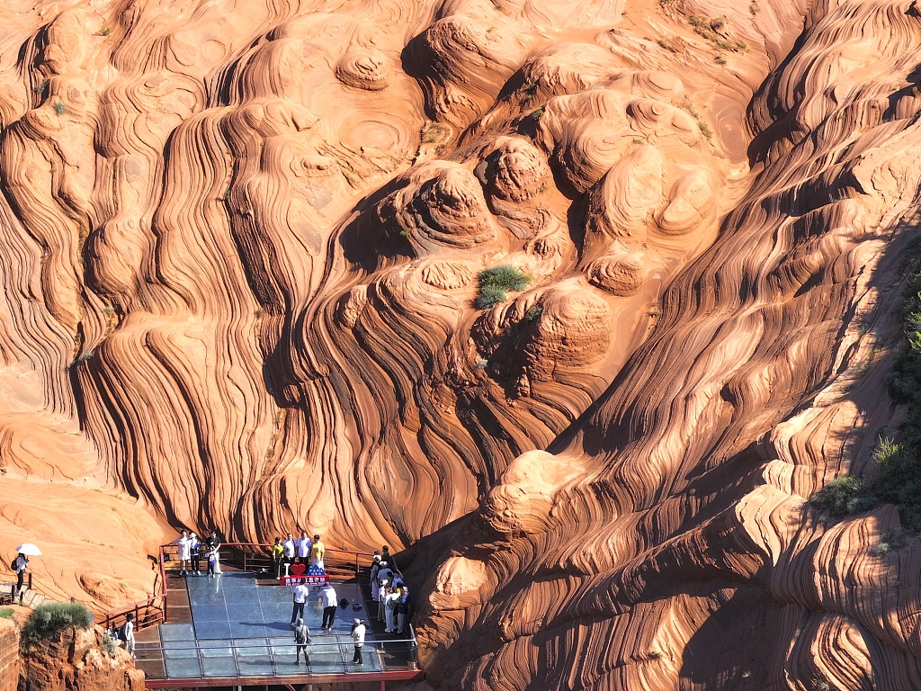 A photo taken on August 13, 2024 shows visitors flocking to Wave Valley to marvel at the breathtaking views of the Danxia landforms in Yulin, Shaanxi Province. /CFP