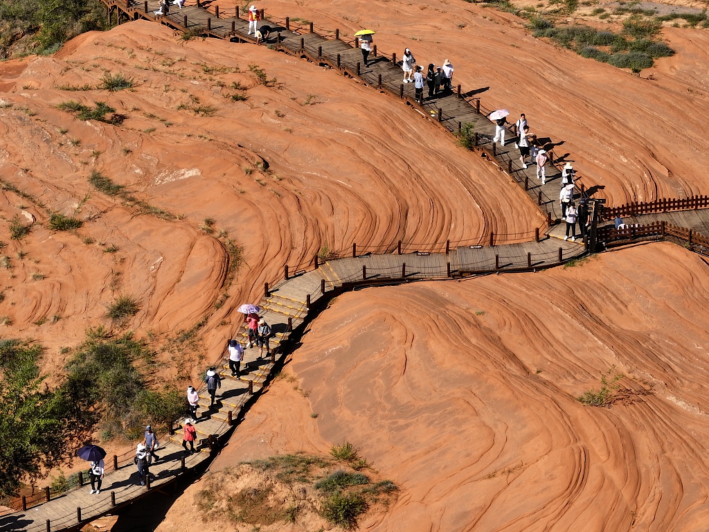 A photo taken on August 13, 2024 shows visitors flocking to Wave Valley to marvel at the breathtaking views of the Danxia landforms in Yulin, Shaanxi Province. /CFP