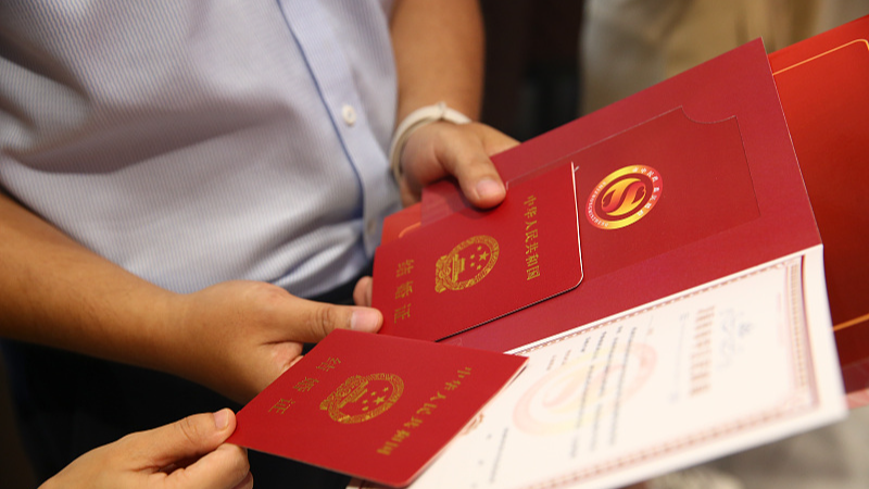 A newlywed couple shows their marriage certificates at the marriage registry of the civil affairs bureau of Shizhong District in Jinan, east China's Shandong Province, August 10, 2024. /CFP