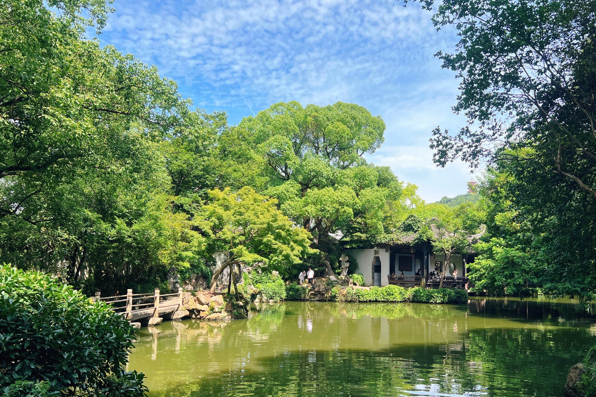 Huishan Mountain and its mountaintop pavilion is seen in the distance from Jichang Garden in Huishan Ancient Town, Wuxi City, Jiangsu Province. /CGTN