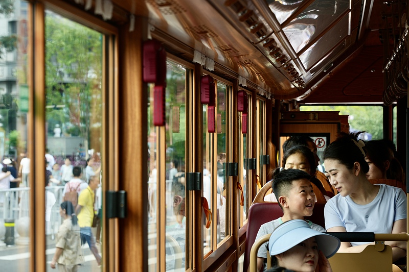 Visitors enjoy leisure time on a tour bus in Beijing, August 17, 2024. /CFP