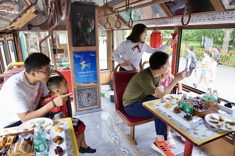 Visitors enjoy leisure time on a tour bus in Beijing, August 17, 2024. /CFP