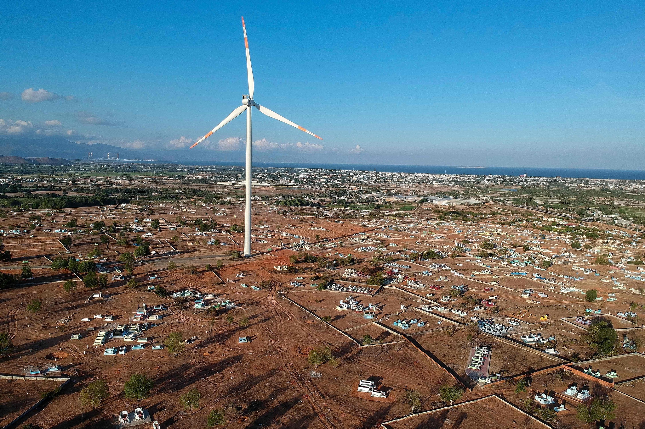 A wind turbine built on the grounds of a cemetery at the Phu Lac wind farm in southern Vietnam's Binh Thuan province. /CFP