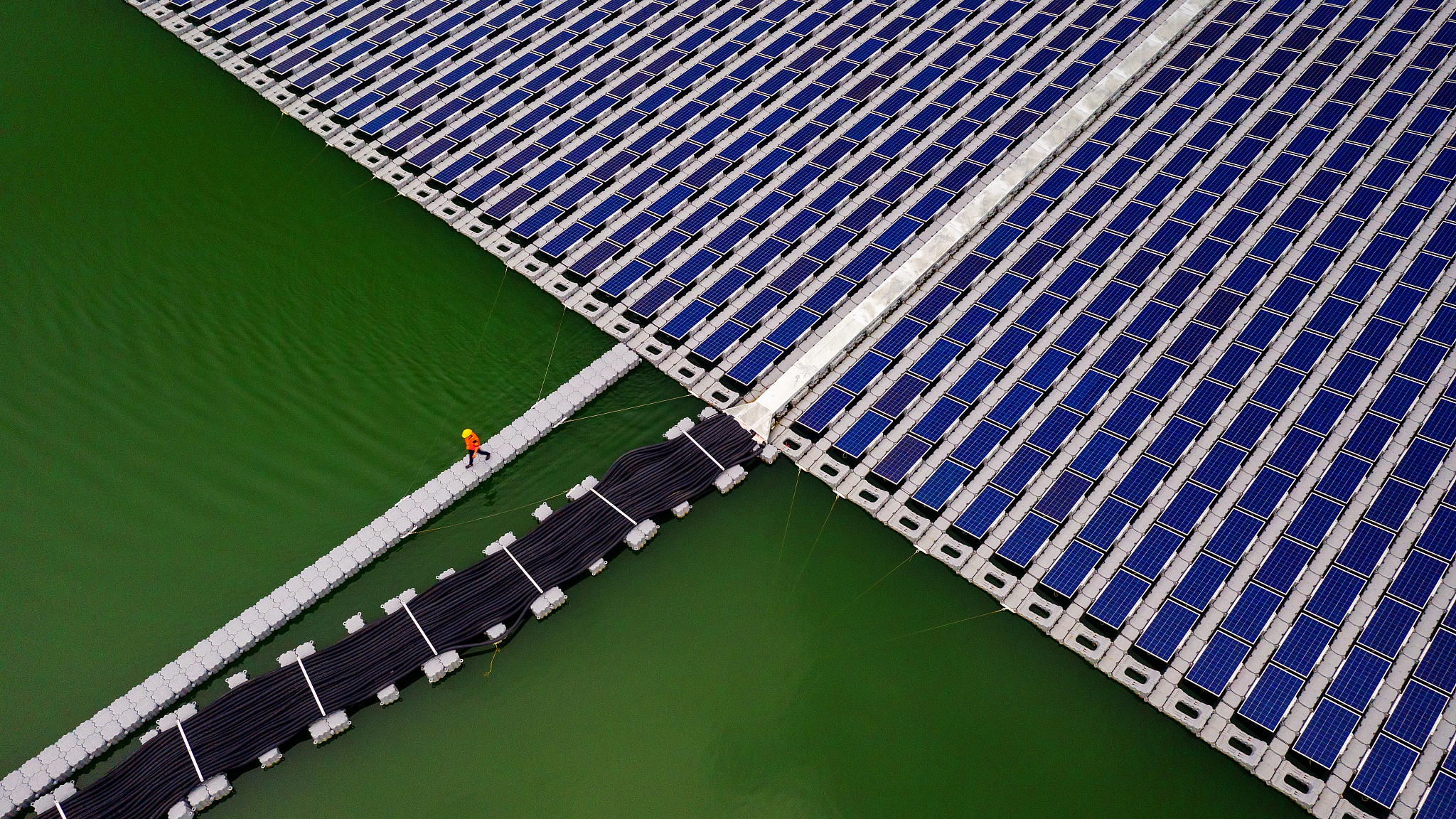 A staff member walks across a floating solar panel farm, the Da Mi power plant, in Binh Thuan province, Vietnam. /CFP