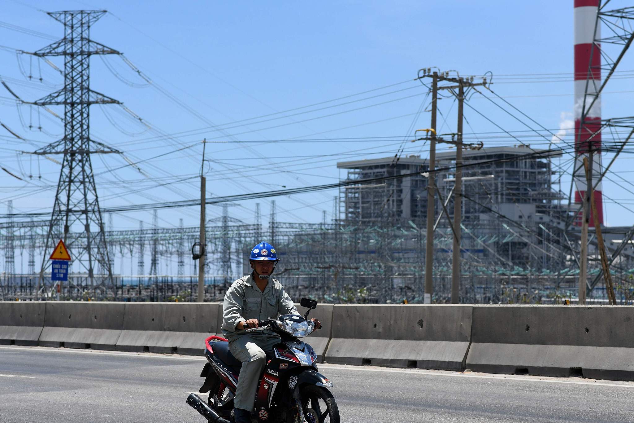 A motorist rides through the Vinh Tan coal power plant in southern Vietnam's Binh Thuan province. /CFP