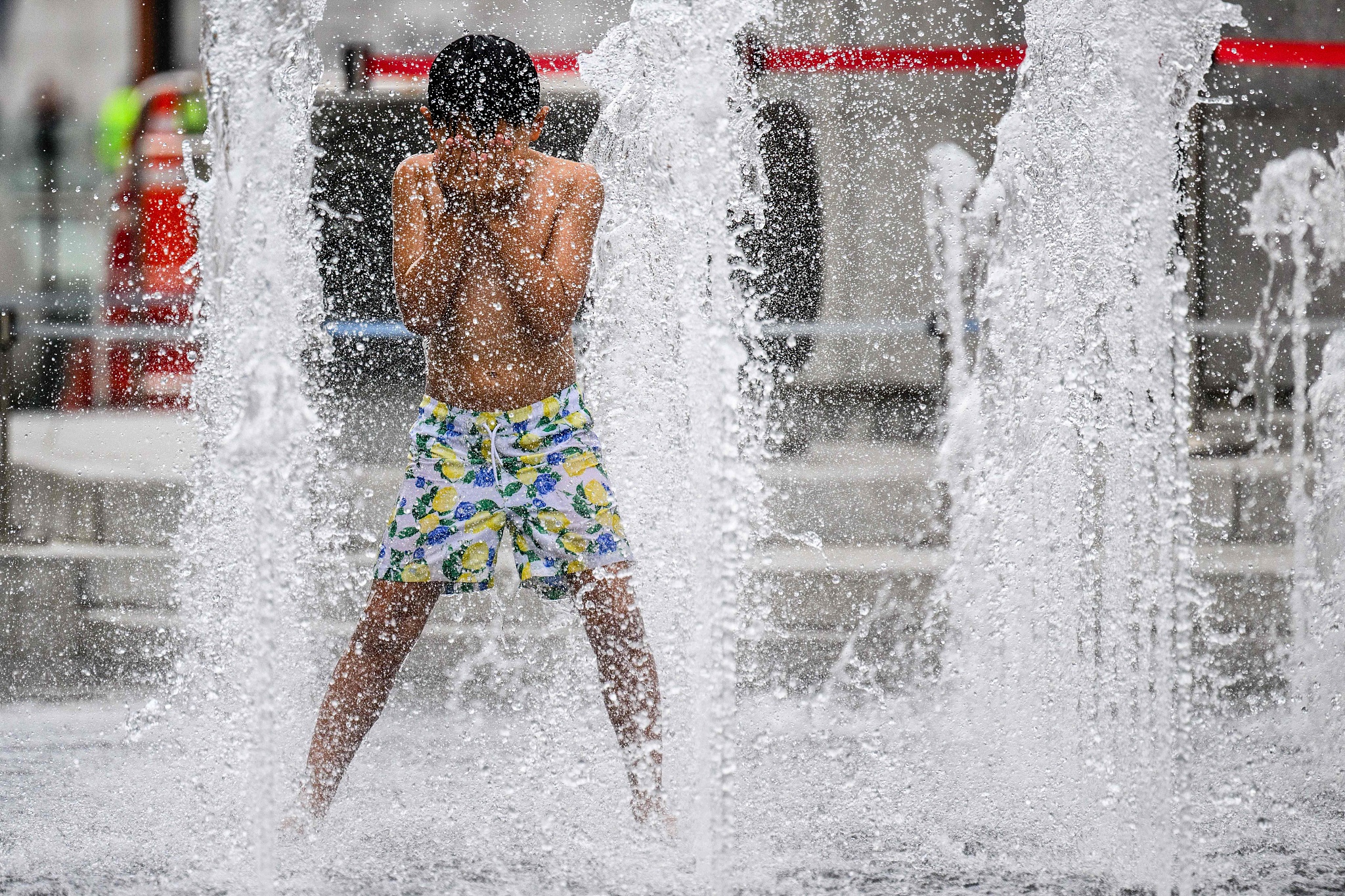 A boy cools off in a water fountain on a street during a prolonged heat wave in Seoul, South Korea, August 14, 2024. /CFP