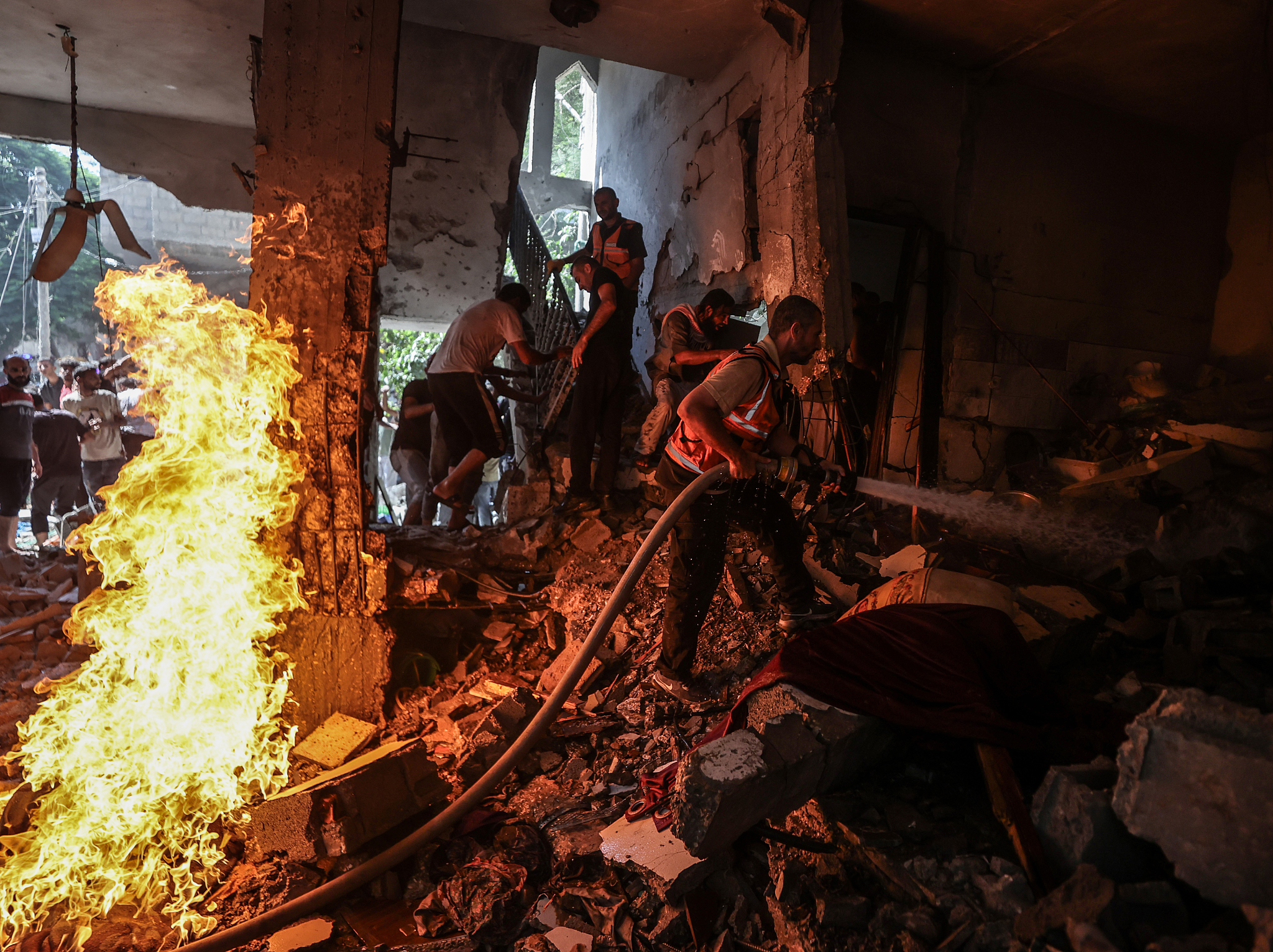 Civilians, civil defense teams and firefighters try to extinguish a fire that broke out as a result of an Israeli army attack at the Nuseirat Refugee Camp in Deir al Balah, Gaza, August 18, 2024. /CFP