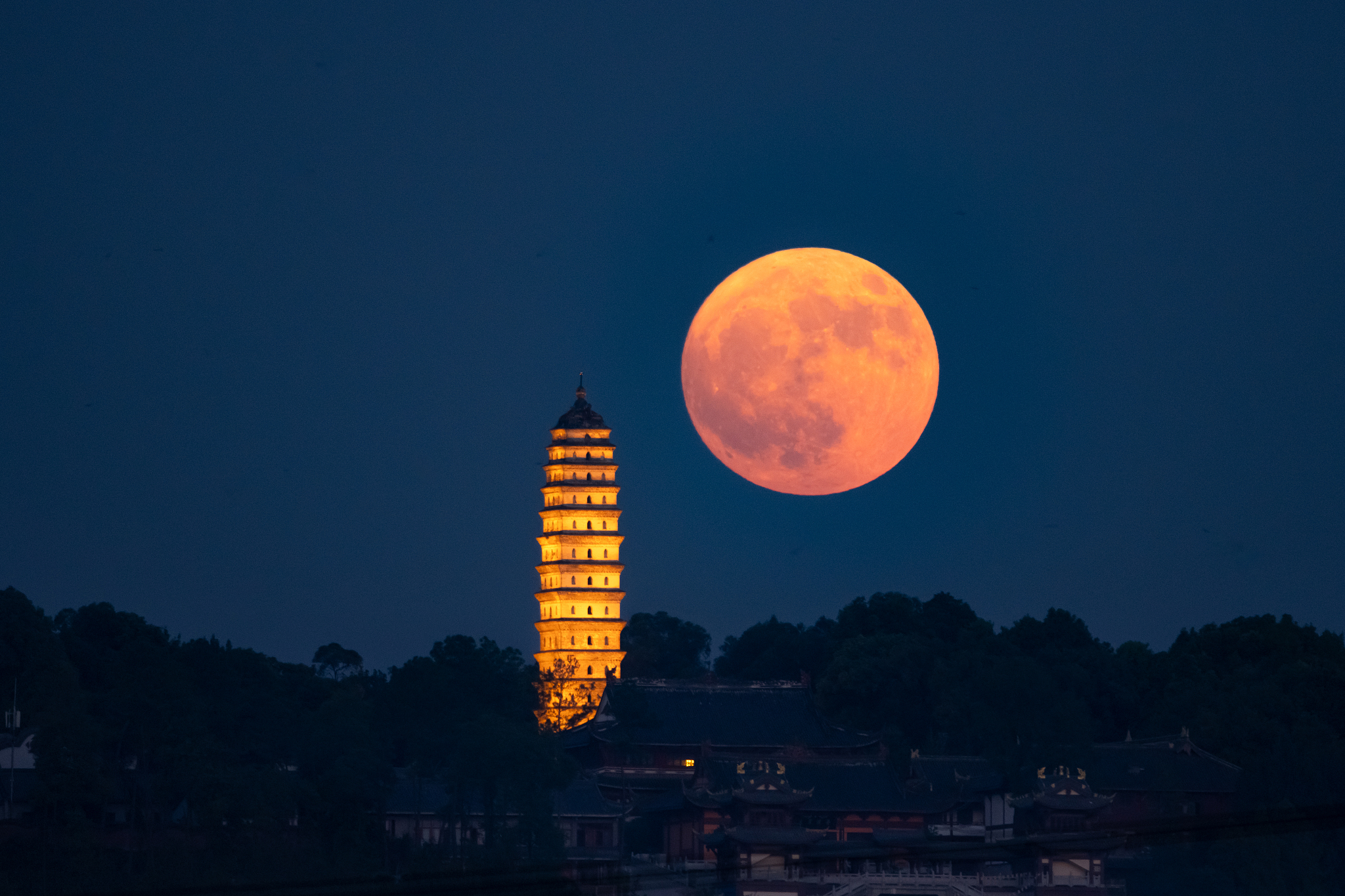 A double exposure photo shows the supermoon and the white tower on Dawang Mountain in Meishan, Sichuan Province on August 19, 2024. /CFP