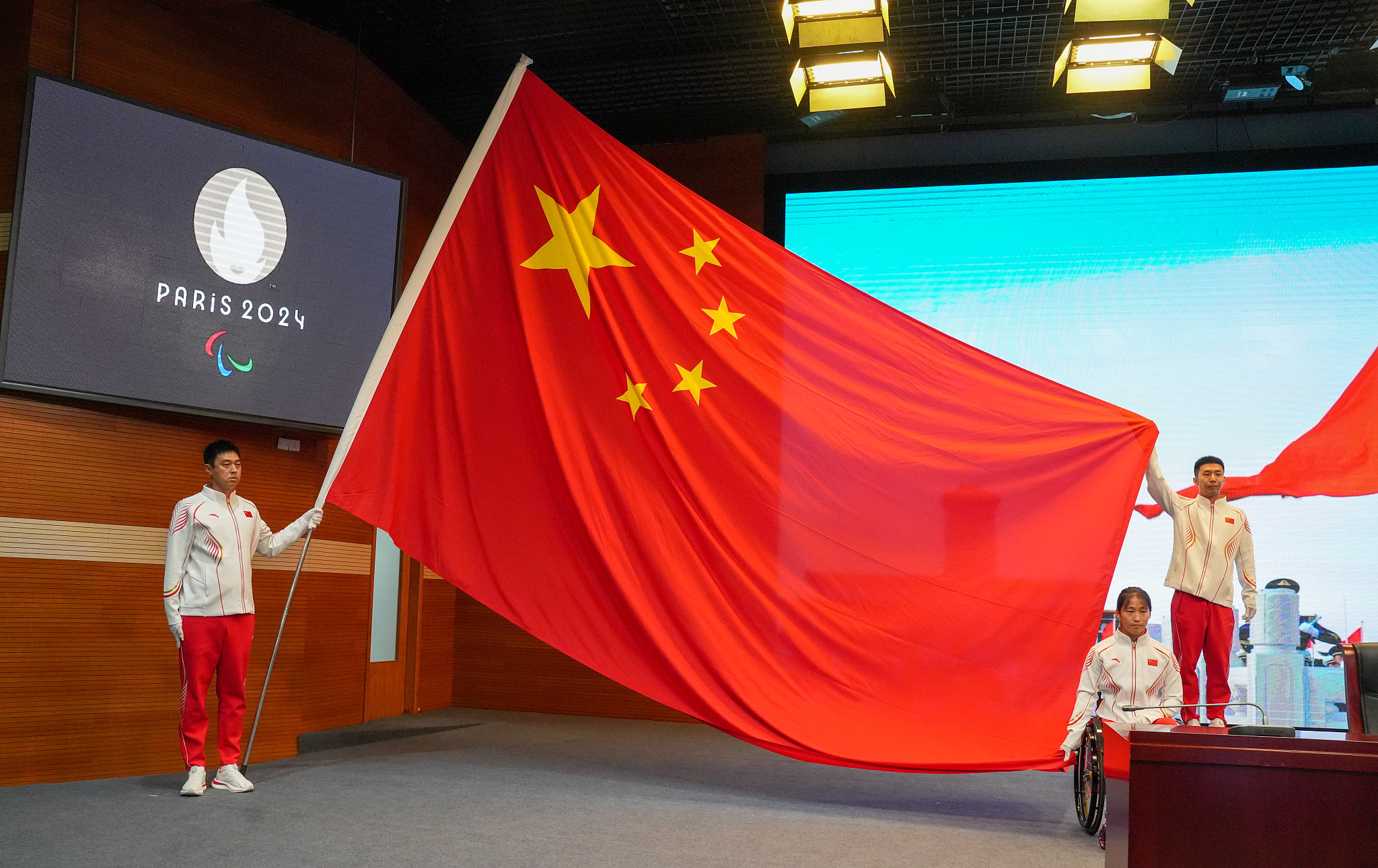 The National Flag of China is presented by representatives of the Chinese Paralympics delegation during a conference in Beijing, China, August 20, 2024. /CFP