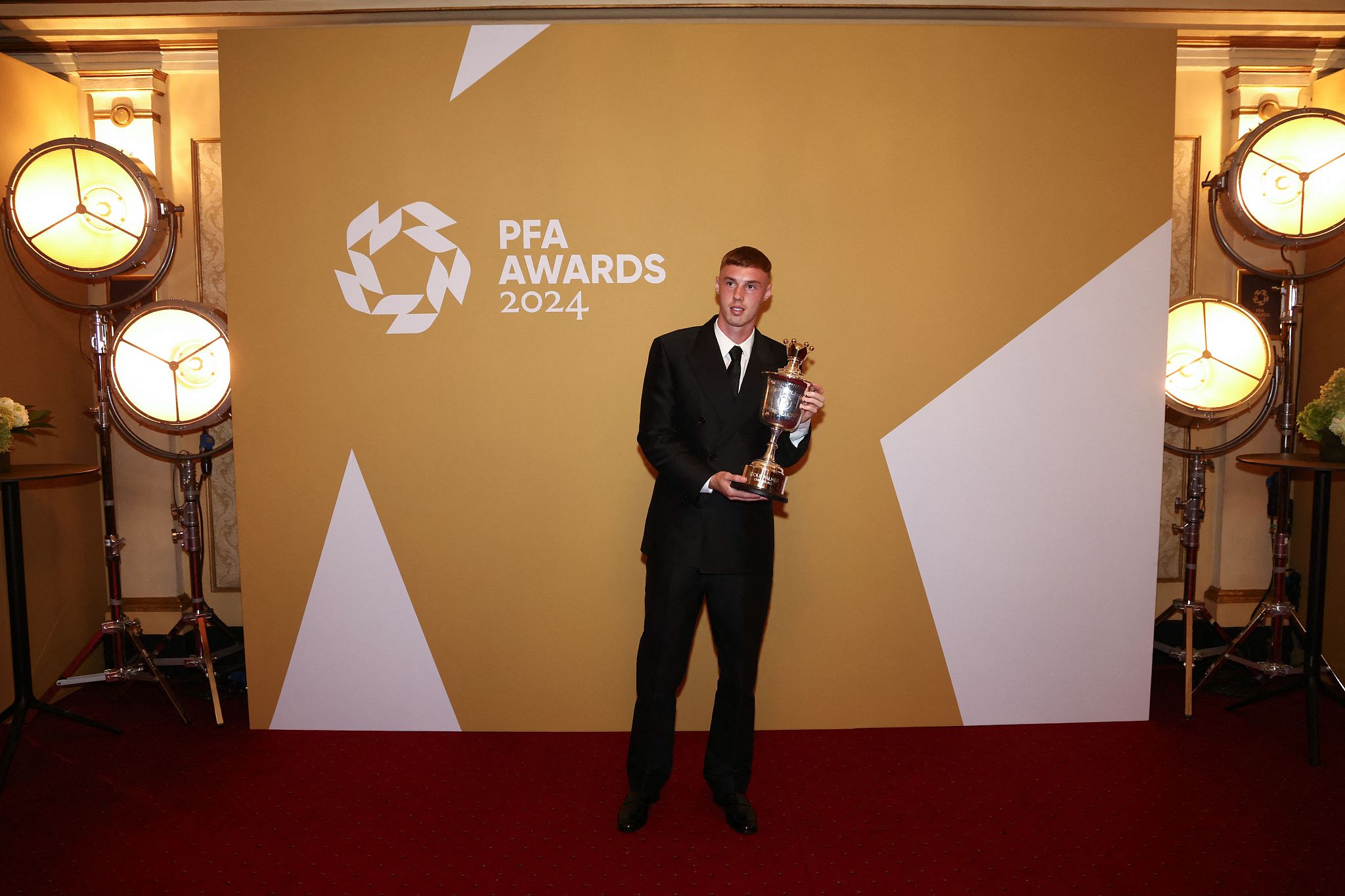 Cole Palmer of Chelsea poses with the Men's PFA Young Player of the Year trophy in the winners' backstage at the Opera House in Manchester, England, August 20, 2024. /CFP