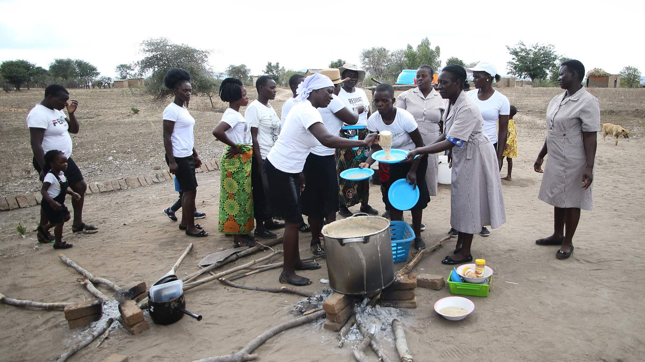 A brigade of nutrition peer educators dish into plates cupfulls of the prepared porridge formulation dubbed maworesa, which translates to the very best porridge. It is cooked with readily available ingredients that are locally sourced to prevent children from falling into malnutrition amid the El-Nino induced drought, Mudzi, Zimbabwe, July 2, 2024. /CFP