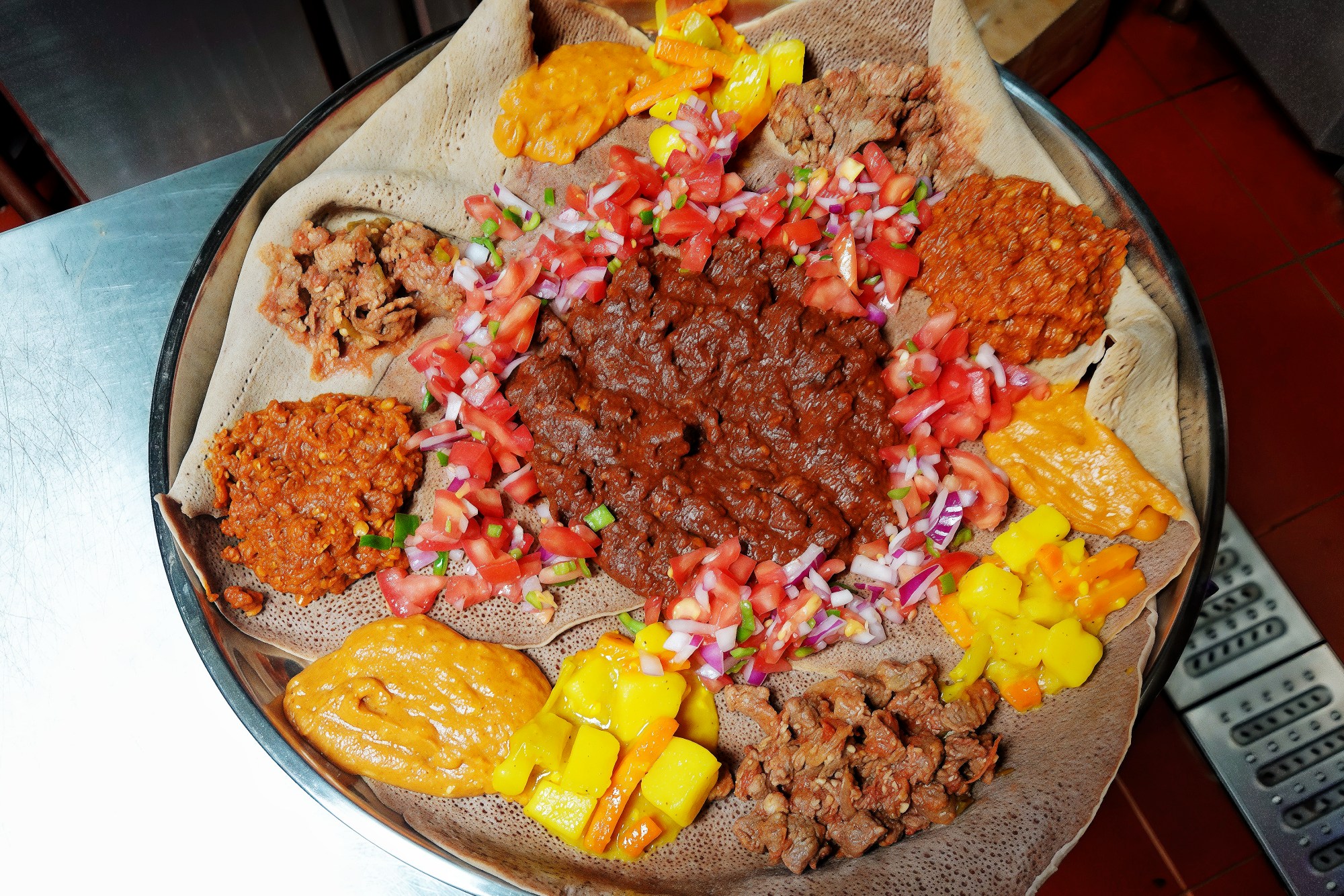 A serving of injera flatbread and various Habesha dishes are pictured at Coded in Beijing on August 8, 2024. /CGTN