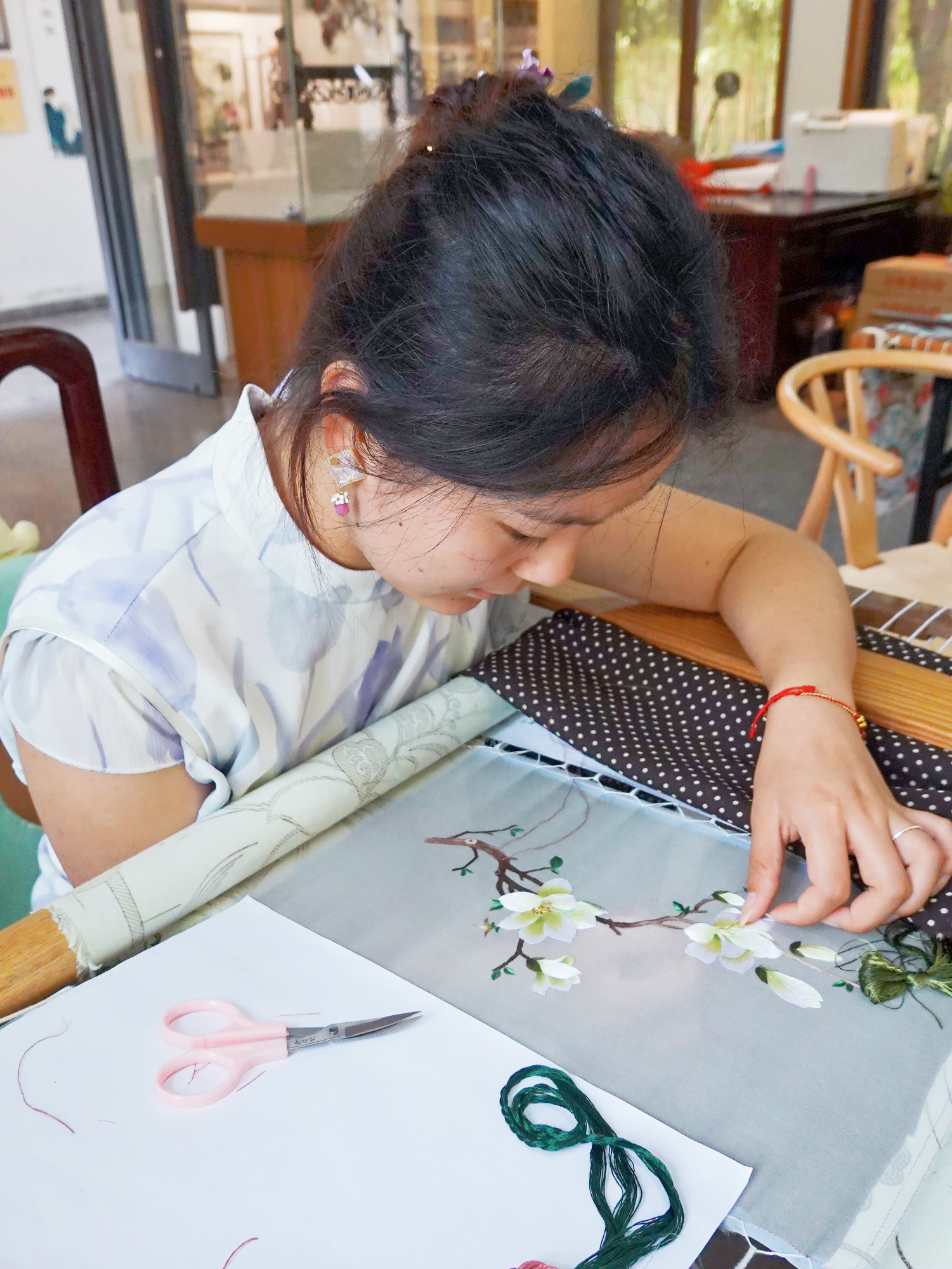 An inheritor demonstrates Wuxi fine embroidery techniques at Huishan Ancient Town in Wuxi, Jiangsu Province July 23, 2024. /CGTN