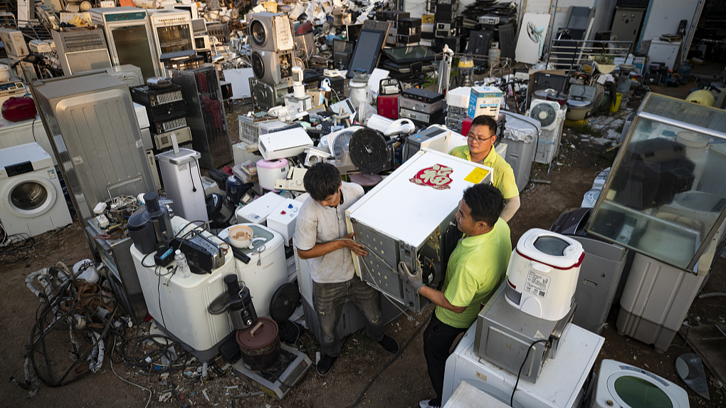 Workers move newly recycled old household appliances at a recycling warehouse in Qingdao, Shandong Province, July 3, 2024. /CFP