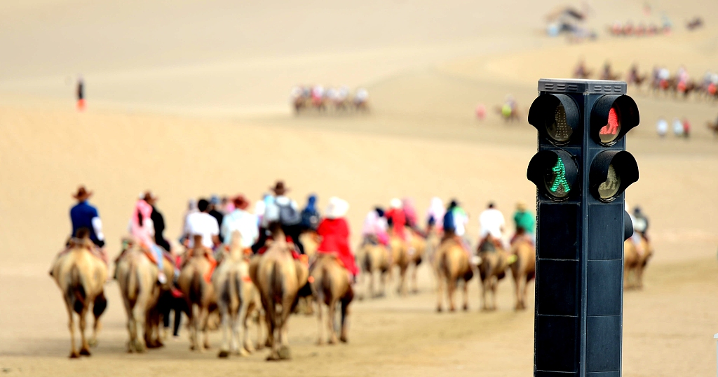 A photo taken on August 23, 2024 shows a set of traffic lights designed for people and camels at the Mingsha Mountain and Crescent Spring scenic spot in Dunhuang, Gansu Province. /CFP