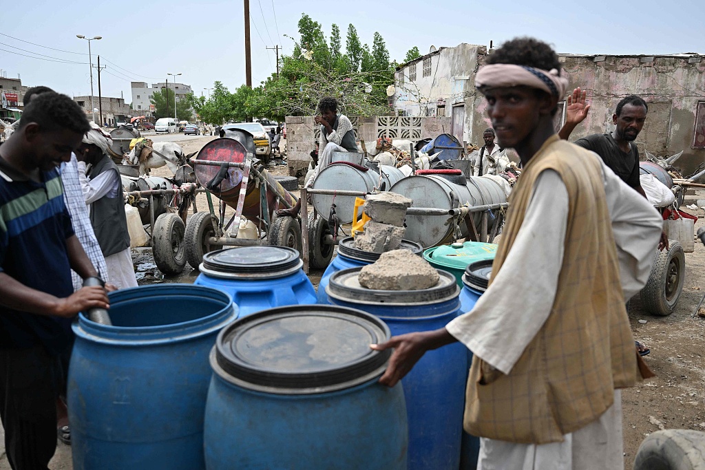 Sudanese people queue to fill on water in Port Sudan, Red Sea State, Sudan on August 26, 2024, after a dam collapsed as a result of heavy rain. /CFP