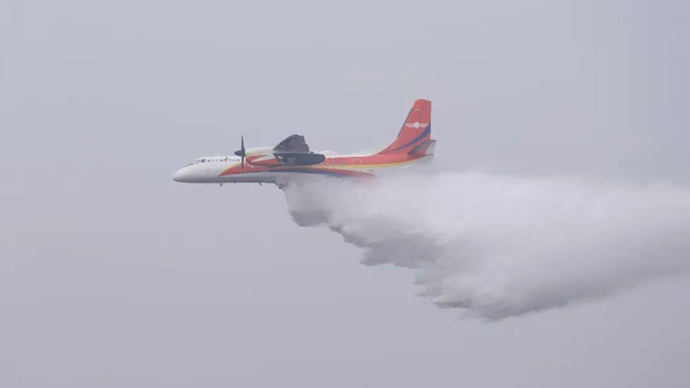 An MA60 firefighting aircraft drops water in the sky above Suining City, southwest China's Sichuan Province, January 27, 2024. /CFP