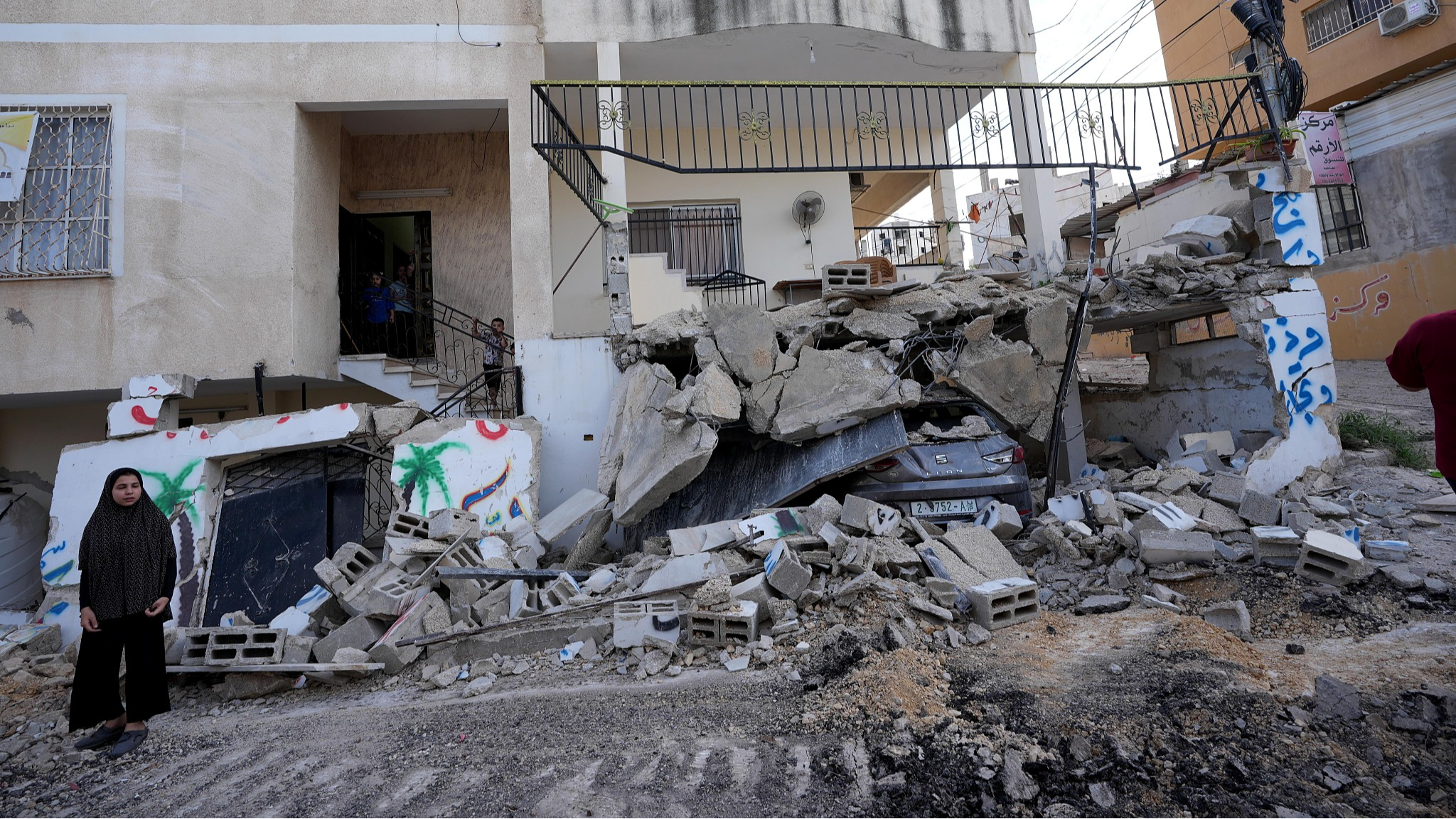 A view of a destroyed vehicle under the debris of demolished building after Israeli forces organized a raid with bulldozers on Nur Shams Refugee Camp in Tulkarm, West Bank, August 28, 2024. /CFP