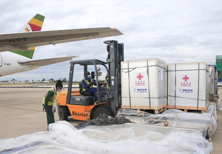 Airport workers offload Chinese-donated COVID-19 vaccines at the Robert Gabriel Mugabe International Airport in Harare, capital of Zimbabwe, February 15, 2021. /Xinhua