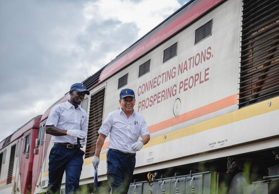 Chinese instructor Jiang Liping (R) and apprentice Horace Owiti walk past a train carriage on the Mombasa-Nairobi Railway in Nairobi, Kenya, May 23, 2023. /Xinhua