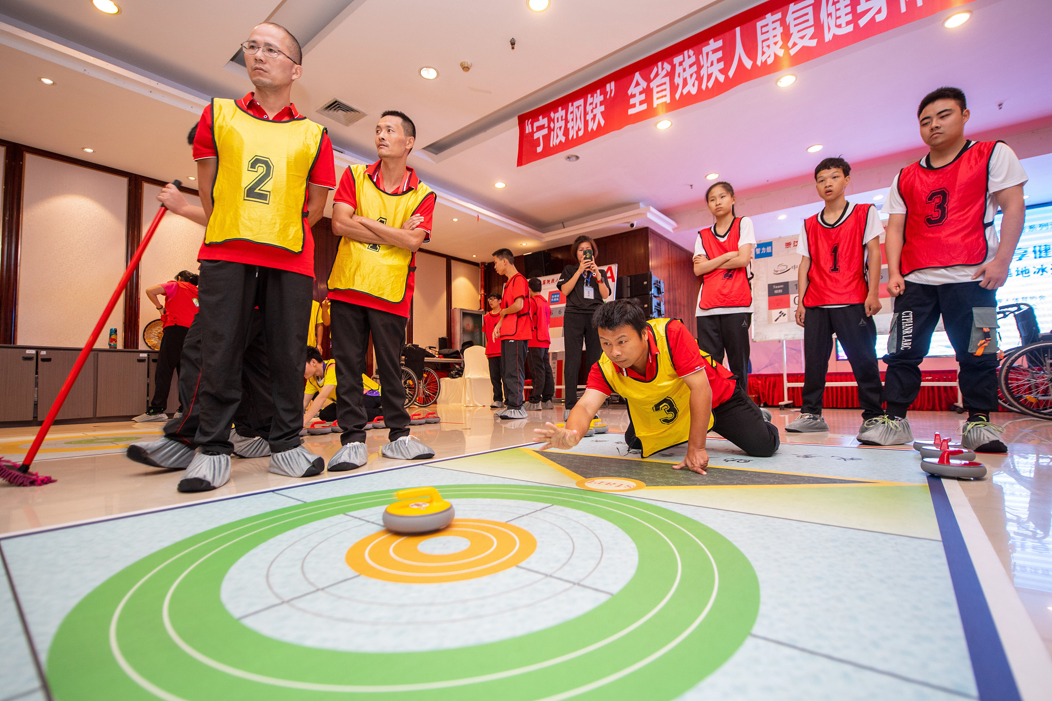 Para penyandang disabilitas berpartisipasi dalam permainan curling di darat di Kota Huzhou, Provinsi Zhejiang, Tiongkok timur, pada 21 September 2023. /CFP