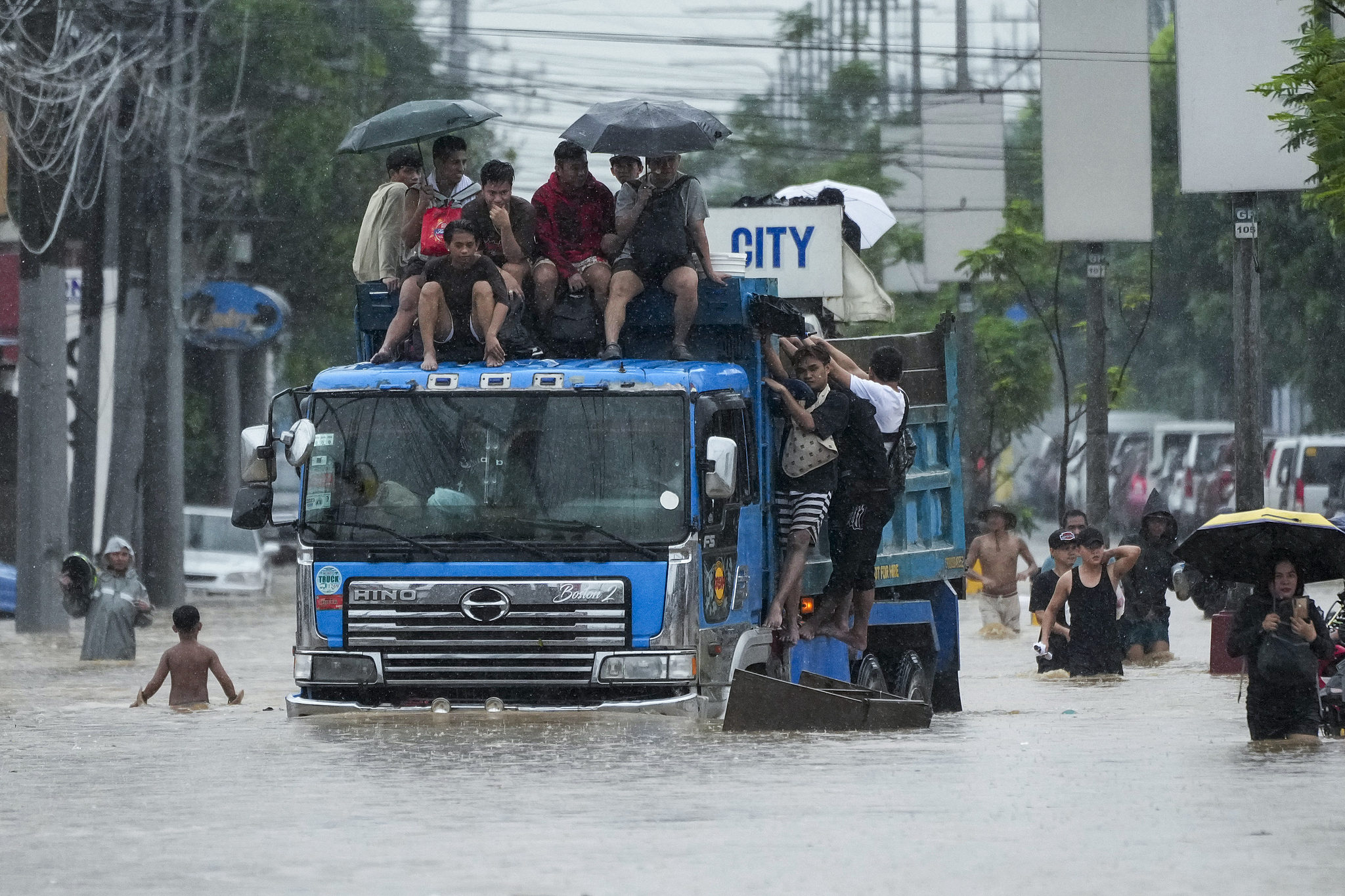 Commuters ride on top of a truck to avoid flood waters caused by heavy rains from tropical storm Yagi in Rizal province, the Philippines, September 2, 2024. /CFP