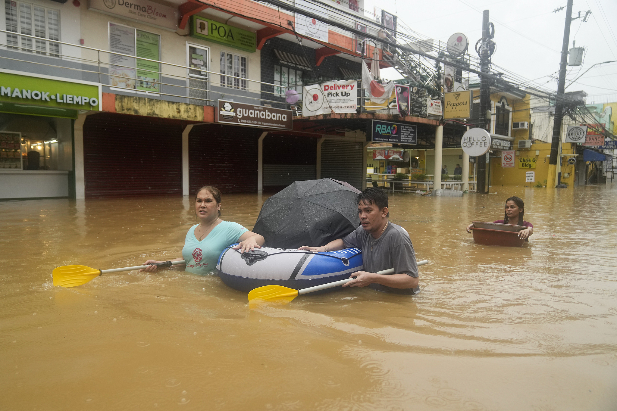 Residents use rubber paddles from a toy boat as they wade along a flooded street caused by heavy rains from tropical storm Yagi in Rizal province, the Philippines, September 2, 2024. /CFP