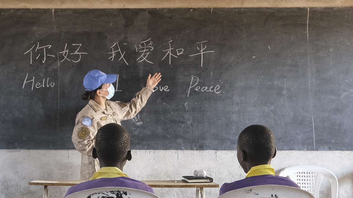 A UN peacekeeper from China teaches local students at a school in Mongalla, South Sudan. /CFP