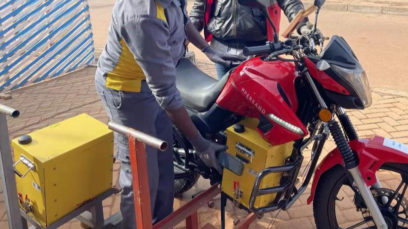 A worker changes a battery for a motorbike driver in Kigali, Rwanda. /Xinhua